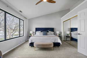 Bedroom with ceiling fan, lofted ceiling, light carpet, and a closet