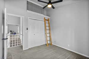 Unfurnished bedroom with ceiling fan, a closet, and carpet