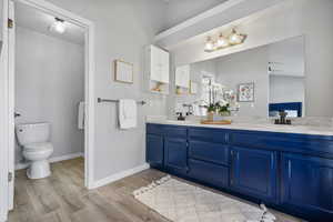 Bathroom featuring hardwood / wood-style flooring, ceiling fan, toilet, and vanity