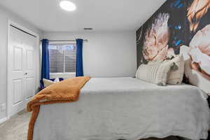 Carpeted bedroom featuring a closet