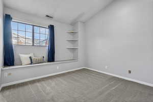 Empty room with carpet and vaulted ceiling