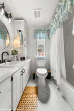 Full bathroom featuring shower / tub combo, vanity, toilet, and crown molding