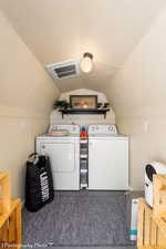 Washroom with washer and dryer and a textured ceiling