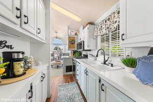 Kitchen with white cabinets, dark hardwood / wood-style floors, sink, and appliances with stainless steel finishes