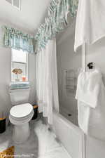 Bathroom with a shower with curtain and toilet