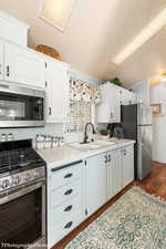 Kitchen with dark hardwood / wood-style flooring, sink, white cabinetry, and stainless steel appliances