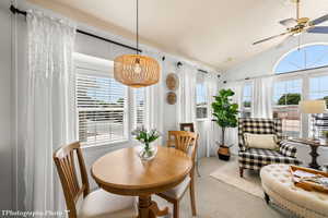 Dining area featuring carpet flooring, ceiling fan, and lofted ceiling