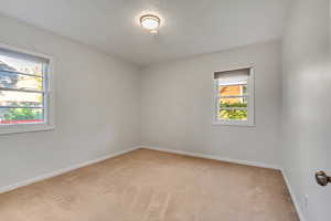 Carpeted spare room featuring a healthy amount of sunlight and a textured ceiling