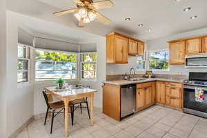 Kitchen with ceiling fan, light tile patterned floors, sink, and appliances with stainless steel finishes