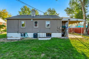 Back of house featuring a yard and central AC unit