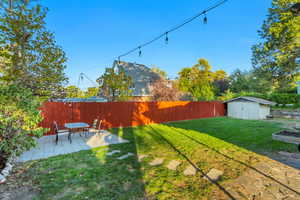 View of yard featuring a shed and a patio