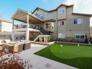 Rear view of property featuring an outdoor living space with a fire pit and a patio