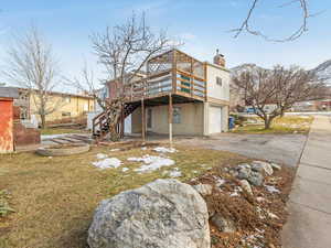 Back of house with a garage and a wooden deck