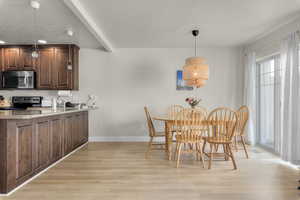 Dining area featuring a textured ceiling, light wood-type flooring, and sink