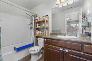 Full bathroom with shower / bath combo, vanity, ceiling fan, tile patterned flooring, and toilet