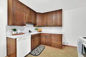 Kitchen featuring dishwasher, stove, and sink