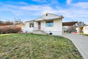 View of front of home with a front lawn and a carport