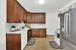 Kitchen with stainless steel fridge, dishwasher, stove, and sink