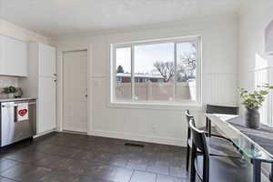 Dining room featuring a textured ceiling and crown molding