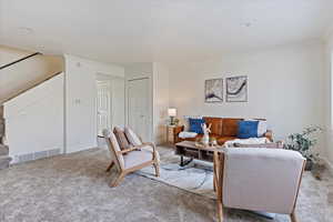 Carpeted living room with ornamental molding