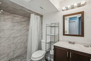 Bathroom with vanity, toilet, and walk in shower