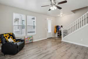 Foyer entrance with ceiling fan and light wood-type flooring