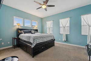 Carpeted bedroom featuring ceiling fan