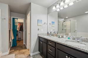 Bathroom featuring vanity, tile patterned floors, and a shower with door