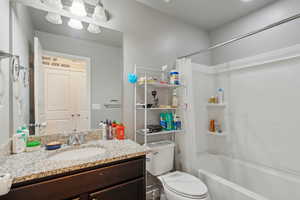 Full bathroom with vanity, toilet, and shower / bathtub combination with curtain