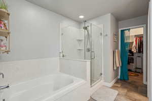 Bathroom featuring shower with separate bathtub