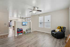 Living area featuring light wood-type flooring and ceiling fan