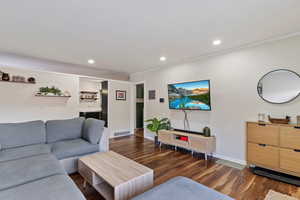 Living room featuring crown molding and dark hardwood / wood-style flooring