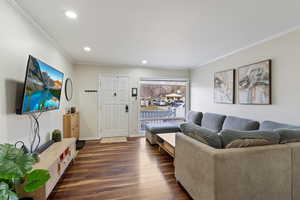 Living room with crown molding and dark hardwood / wood-style flooring