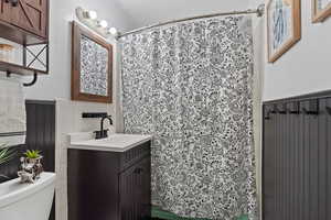 Bathroom with a shower with curtain, vanity, and toilet