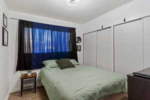 Bedroom featuring wood-type flooring and two closets