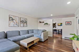 Living room featuring dark hardwood / wood-style floors and ornamental molding