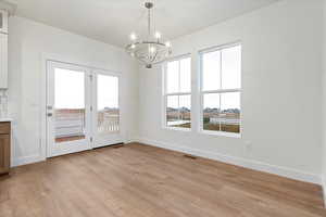 Unfurnished dining area with light hardwood / wood-style floors and a chandelier