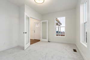 Spare room featuring carpet flooring and french doors