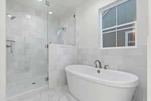 Bathroom with separate shower and tub and tile walls