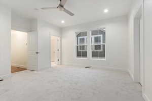 Empty room featuring ceiling fan and light carpet