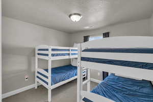 Bedroom featuring carpet flooring and a textured ceiling