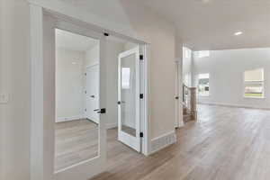 Corridor featuring light wood-type flooring