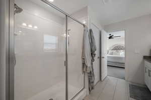 Bathroom with vanity, an enclosed shower, and ceiling fan