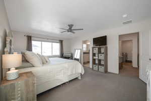 Bedroom with carpet floors, ensuite bathroom, and ceiling fan