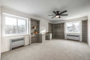 Misc room with light colored carpet, crown molding, and radiator