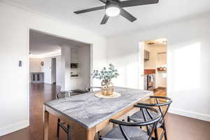 Dining space featuring crown molding, ceiling fan, and dark hardwood / wood-style floors