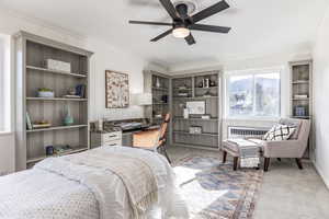 Bedroom with radiator, light colored carpet, ceiling fan, and crown molding