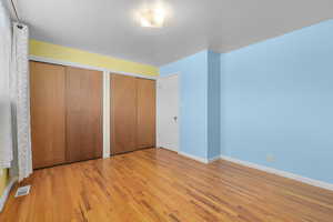 Unfurnished bedroom featuring two closets and light hardwood / wood-style flooring