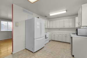 Kitchen with white appliances and white cabinetry