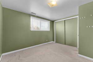 Unfurnished bedroom featuring light colored carpet and a closet